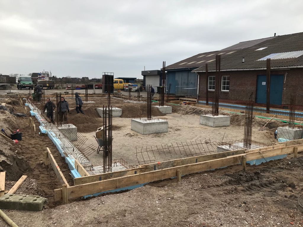 Eine Gruppe von Menschen arbeitet auf einer Baustelle vor einem Gebäude.