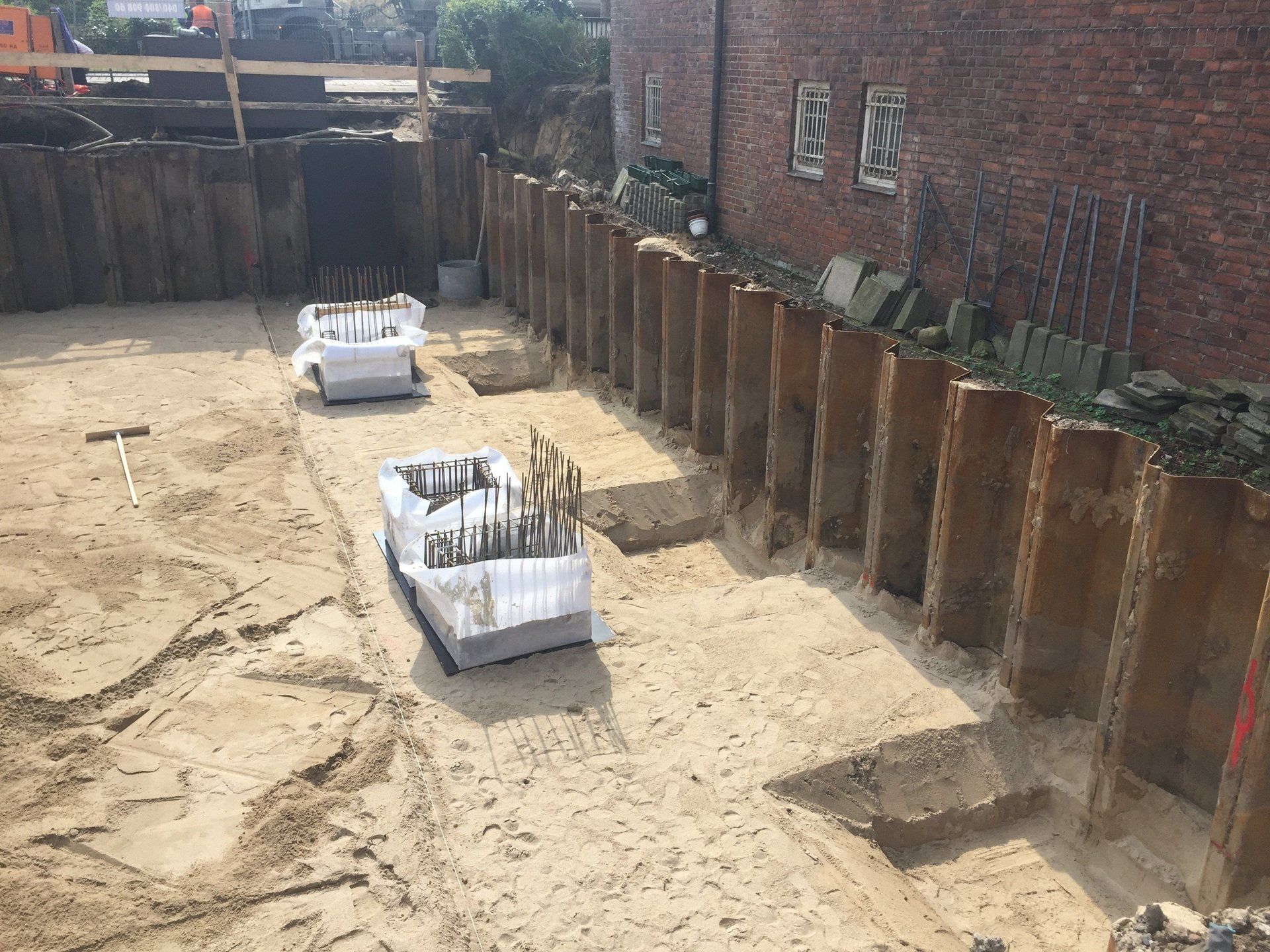 Eine Baustelle mit einer Backsteinmauer und Erdhaufen.