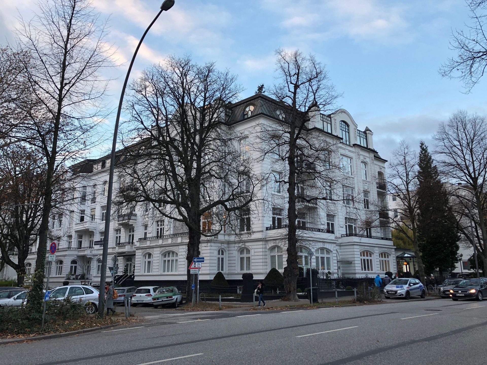 Ein großes weißes Gebäude mit davor geparkten Autos