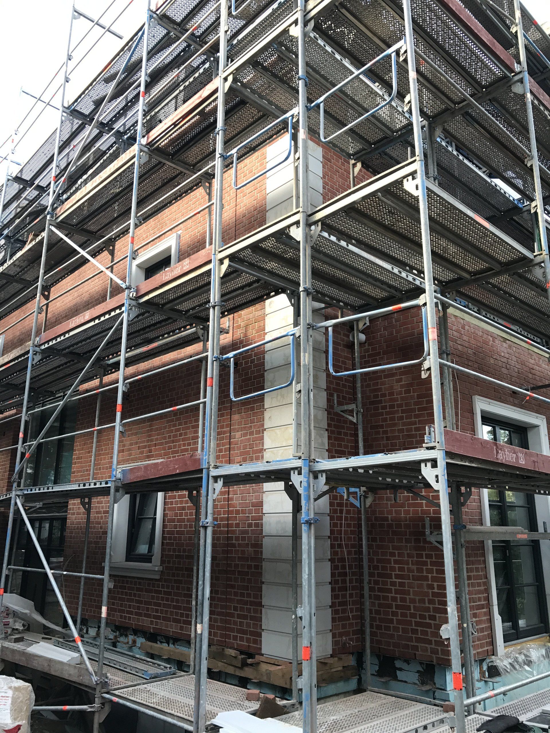 Es wird ein Backsteingebäude mit Gerüst darum errichtet.