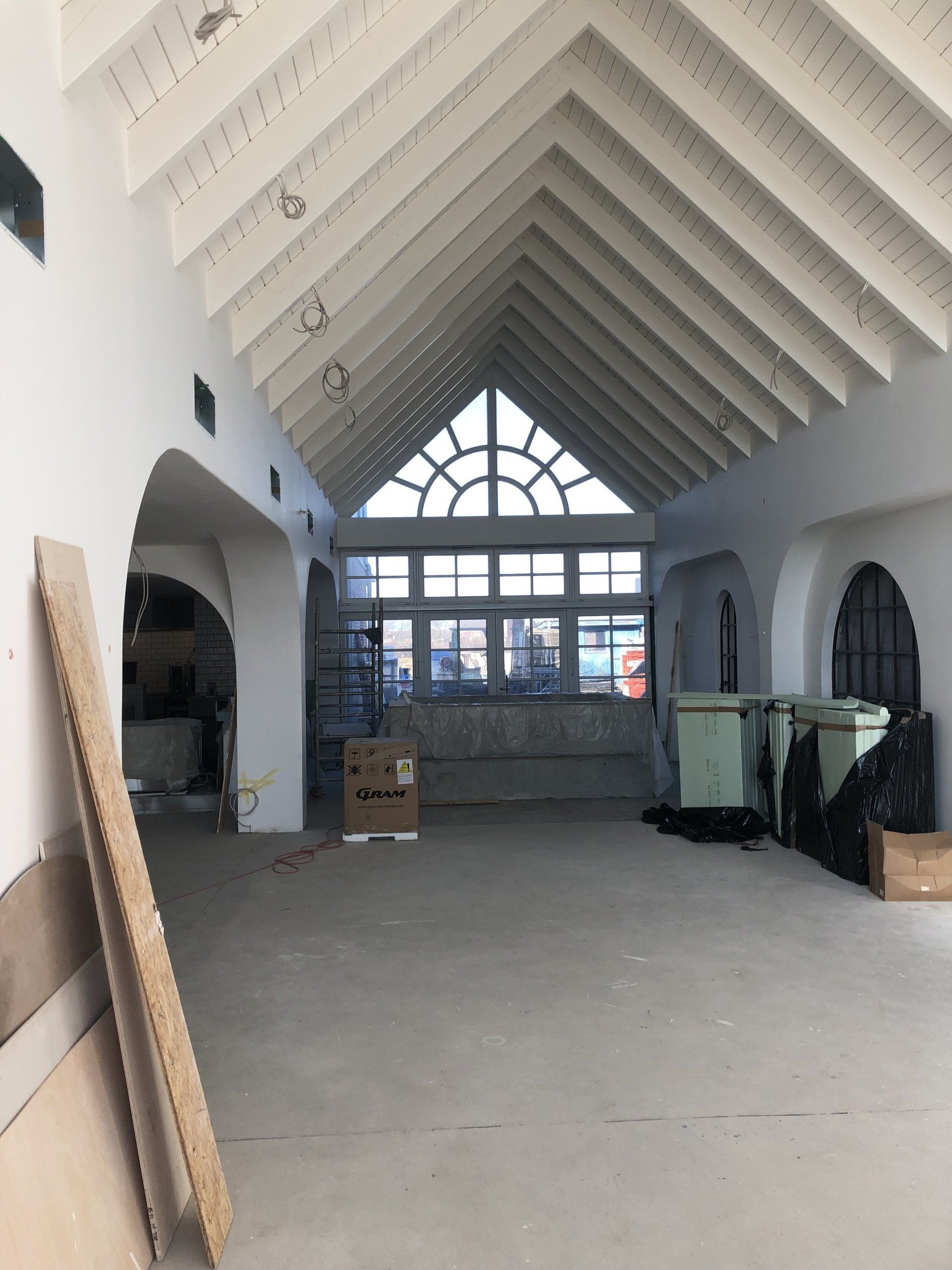 Ein leerer Raum mit gewölbter Decke und Bogenfenstern