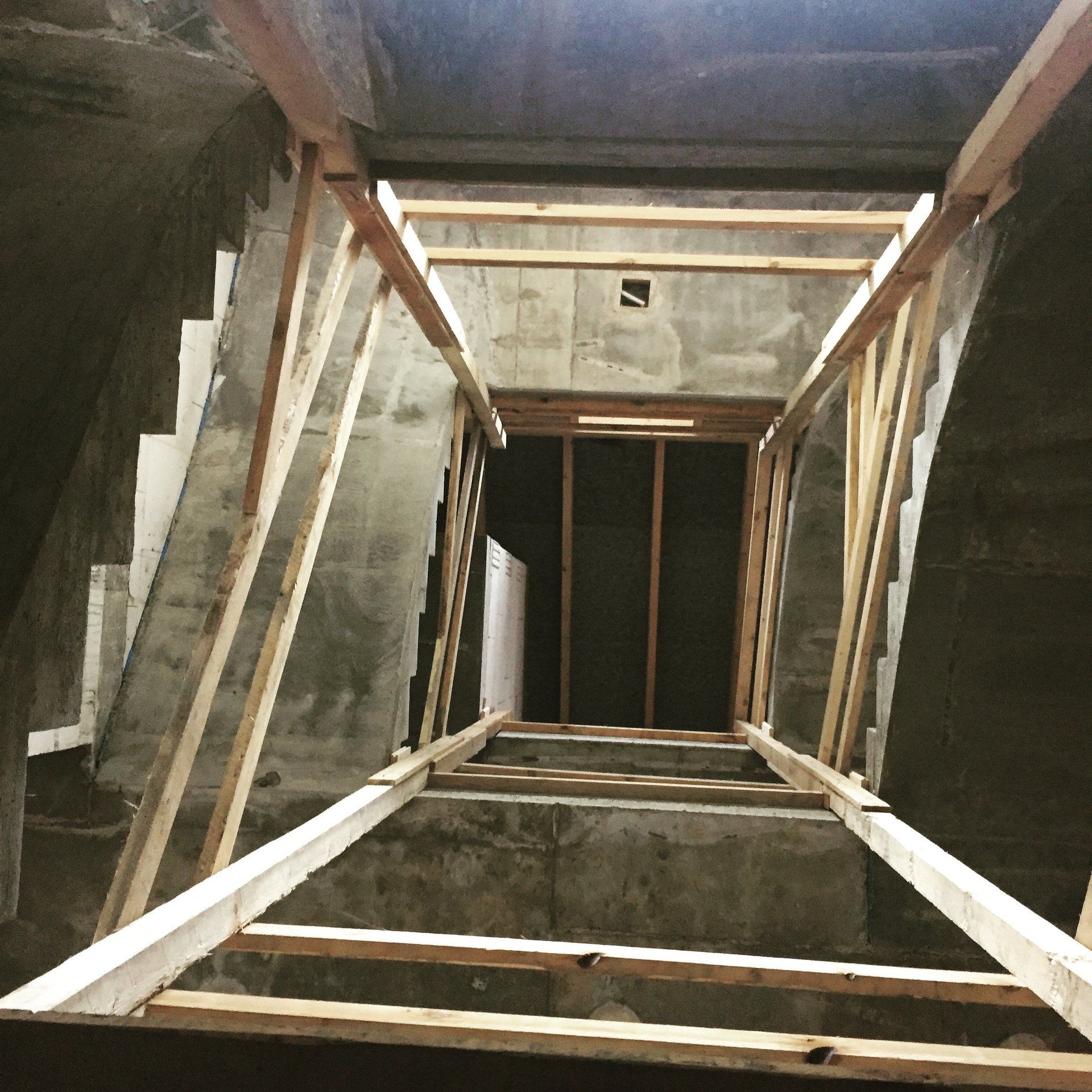 Blick nach oben auf eine Treppe mit Holzbalken