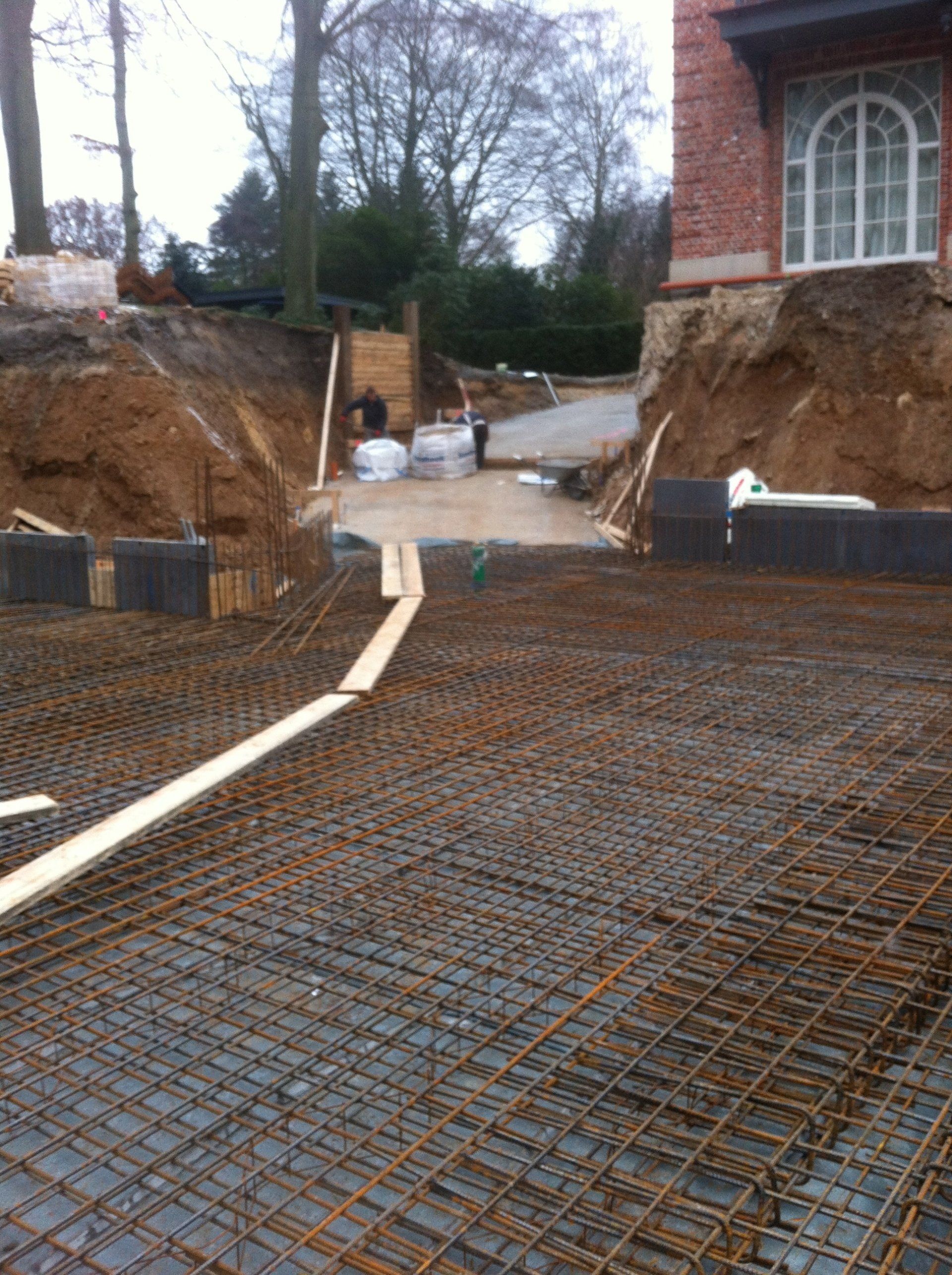 Vor einem Haus wird ein Betonboden gebaut.