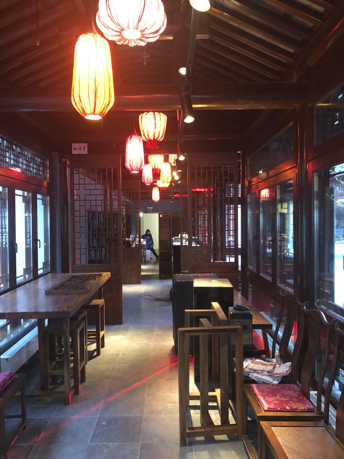 Ein Restaurant mit Tischen und Stühlen und Laternen, die von der Decke hängen