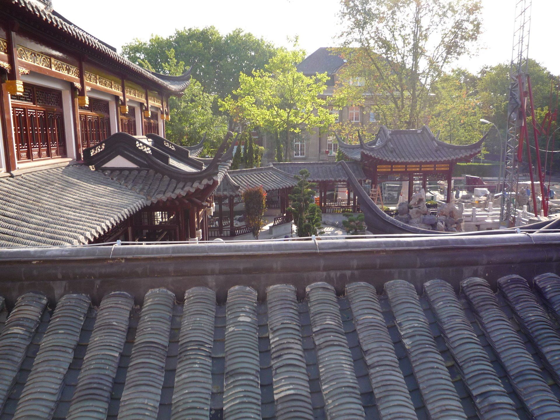 Blick vom Dach eines chinesischen Gebäudes mit Bäumen im Hintergrund