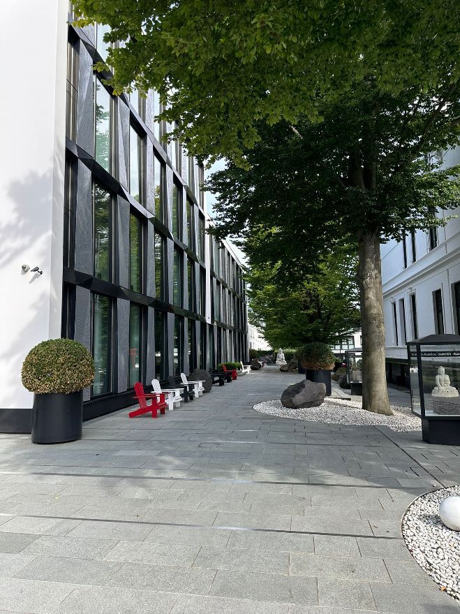 Ein Gebäude mit vielen Fenstern und Bäumen davor.