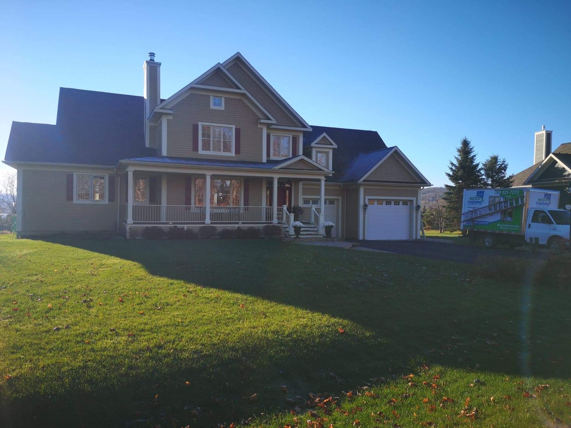 Une grande maison avec un camion garé devant
