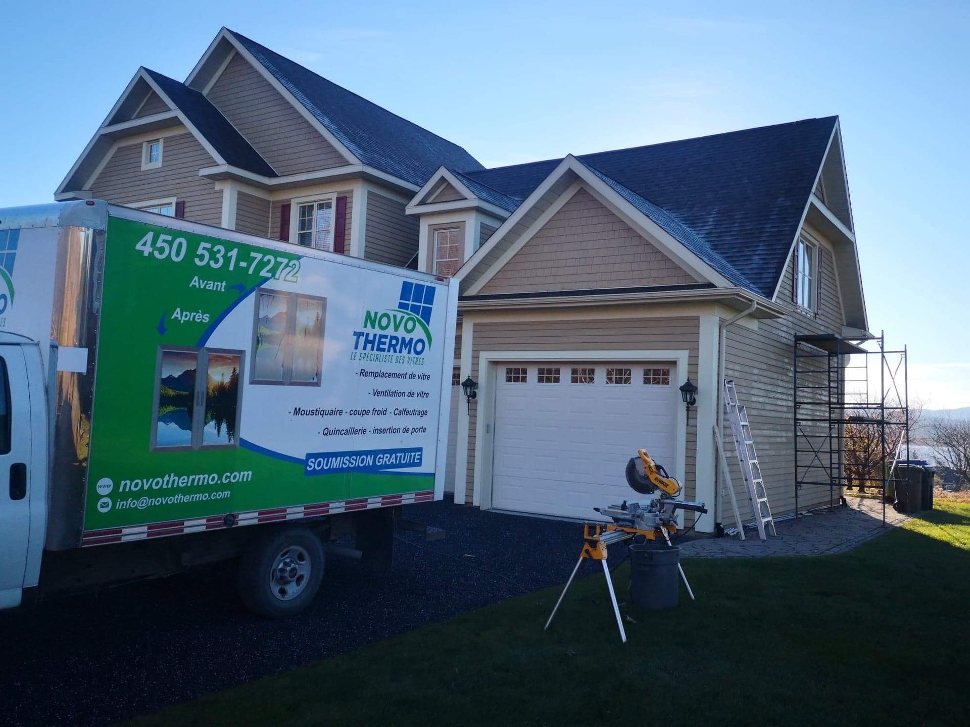 Un camion vert est garé devant une maison