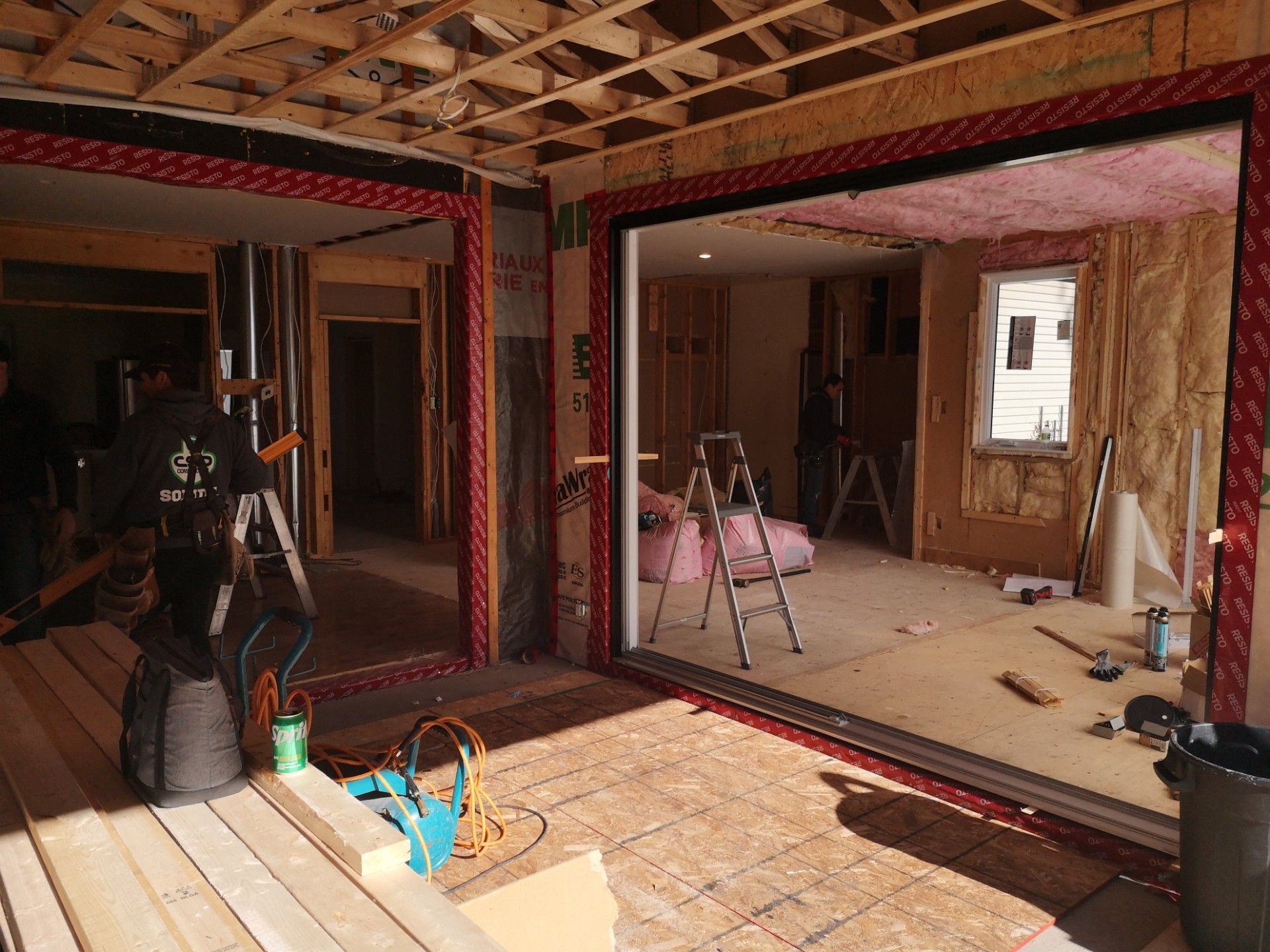 Une maison est en construction avec une grande porte coulissante en verre.