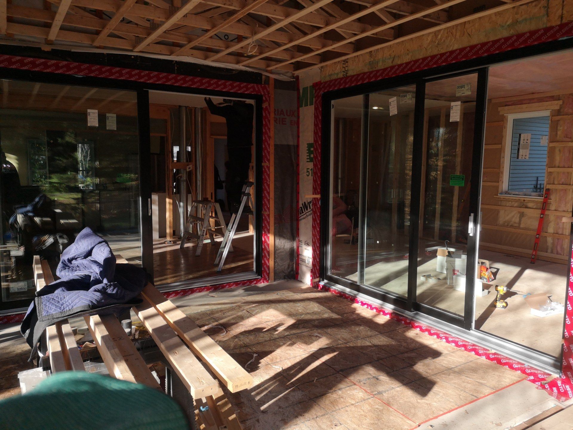Une pièce avec beaucoup de fenêtres et de portes coulissantes en verre est en cours de construction.