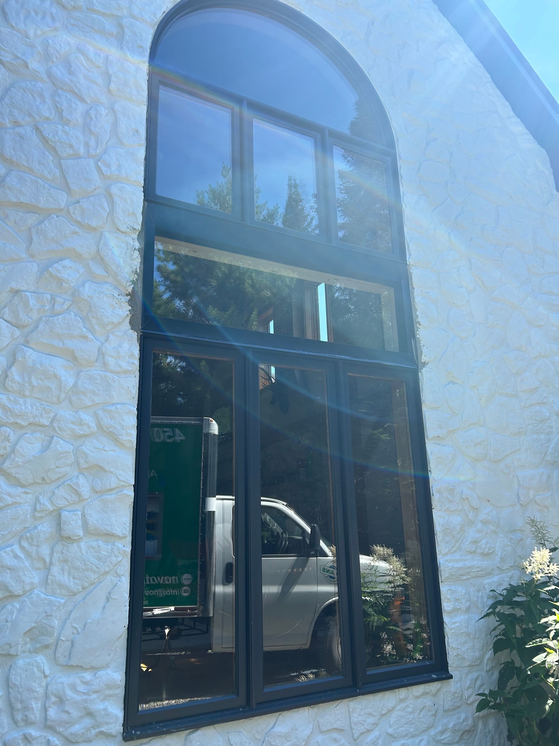 Un camion blanc est garé devant une grande fenêtre sur le côté d'un bâtiment.