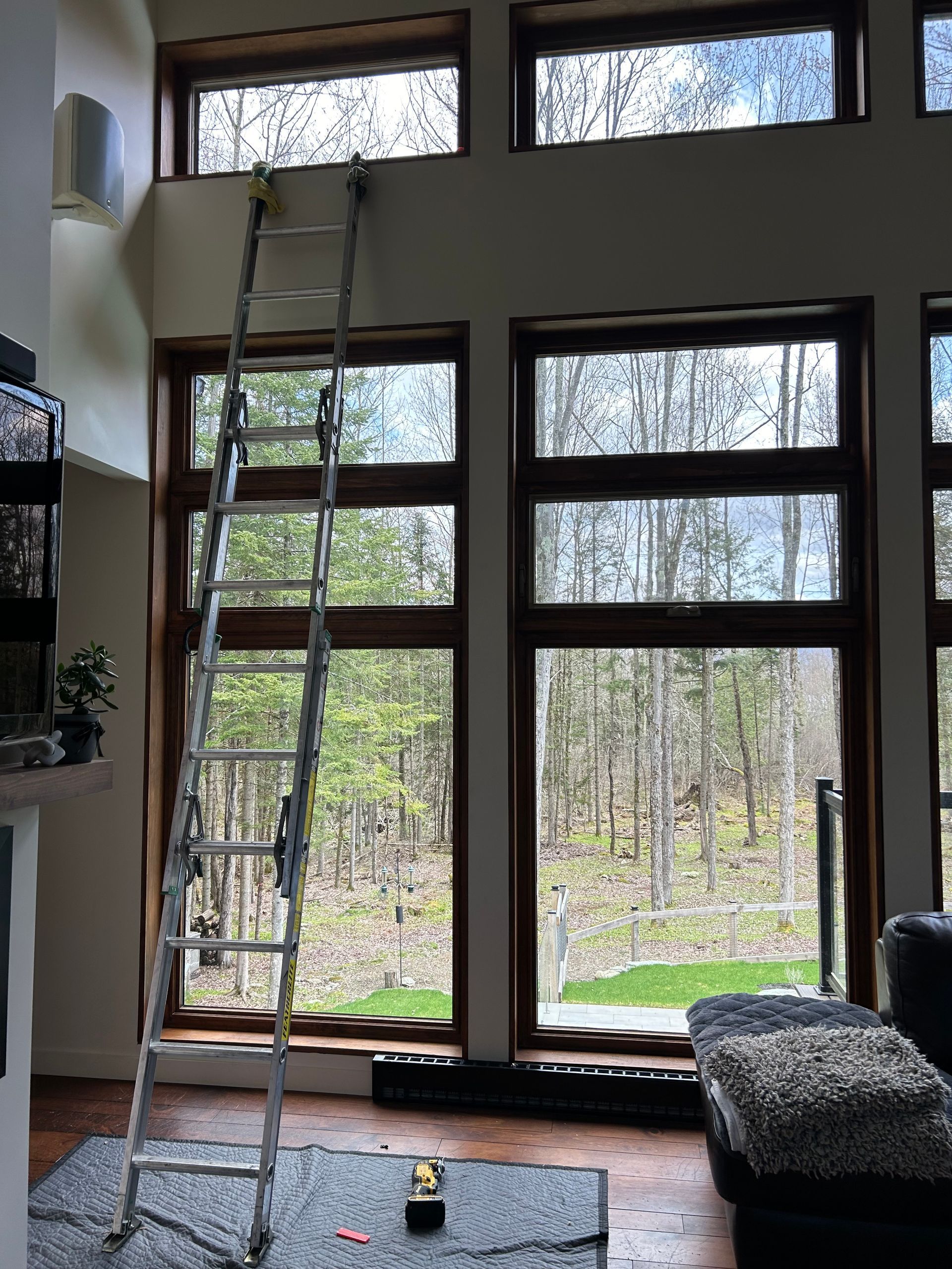 Une échelle dans un salon avec beaucoup de fenêtres