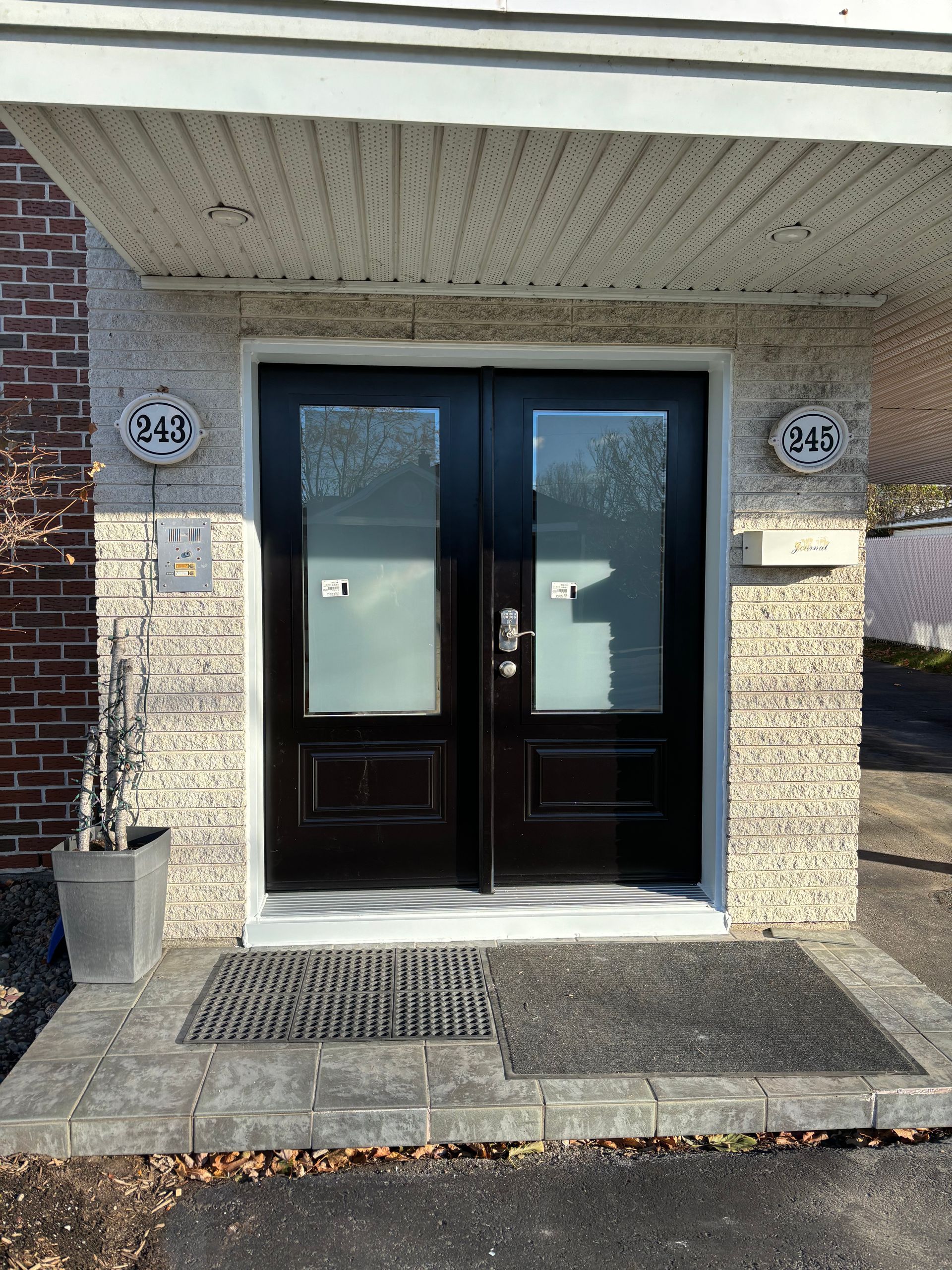 La porte d'entrée d'une maison en briques avec une porte noire