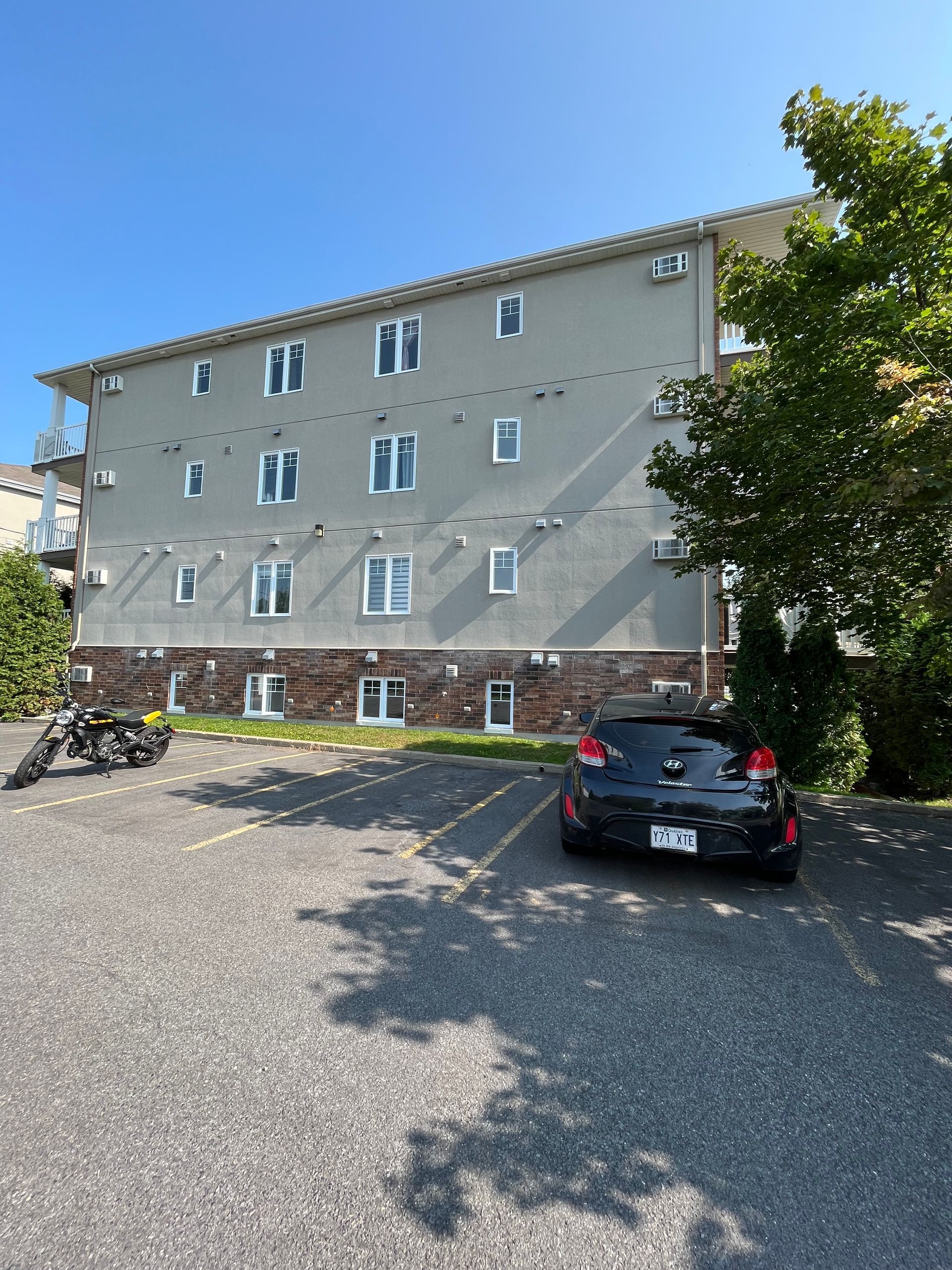 Une voiture noire est garée devant un grand bâtiment