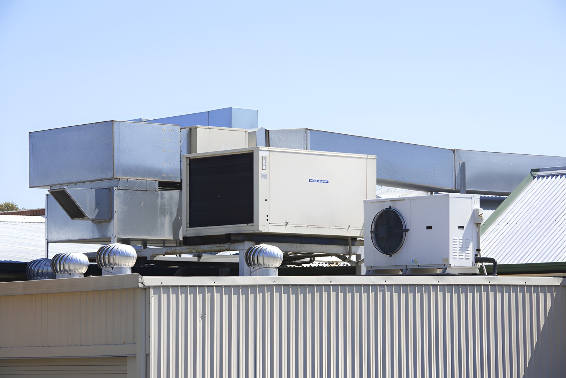 Hvac Units on a Building Roof, With Metal Ducts — Brian Williams Electrical Air Solar in Cooroibah, QLD