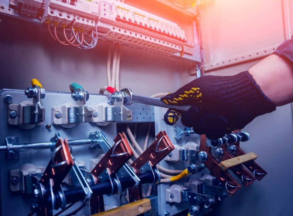 Gloved Hand Operating Electrical Panel Switches — Brian Williams Electrical Air Solar in Cooroibah, QLD