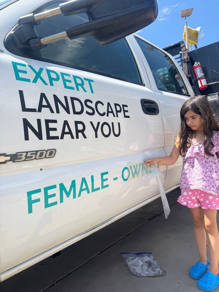 Girl peeling a sticker from a white truck with