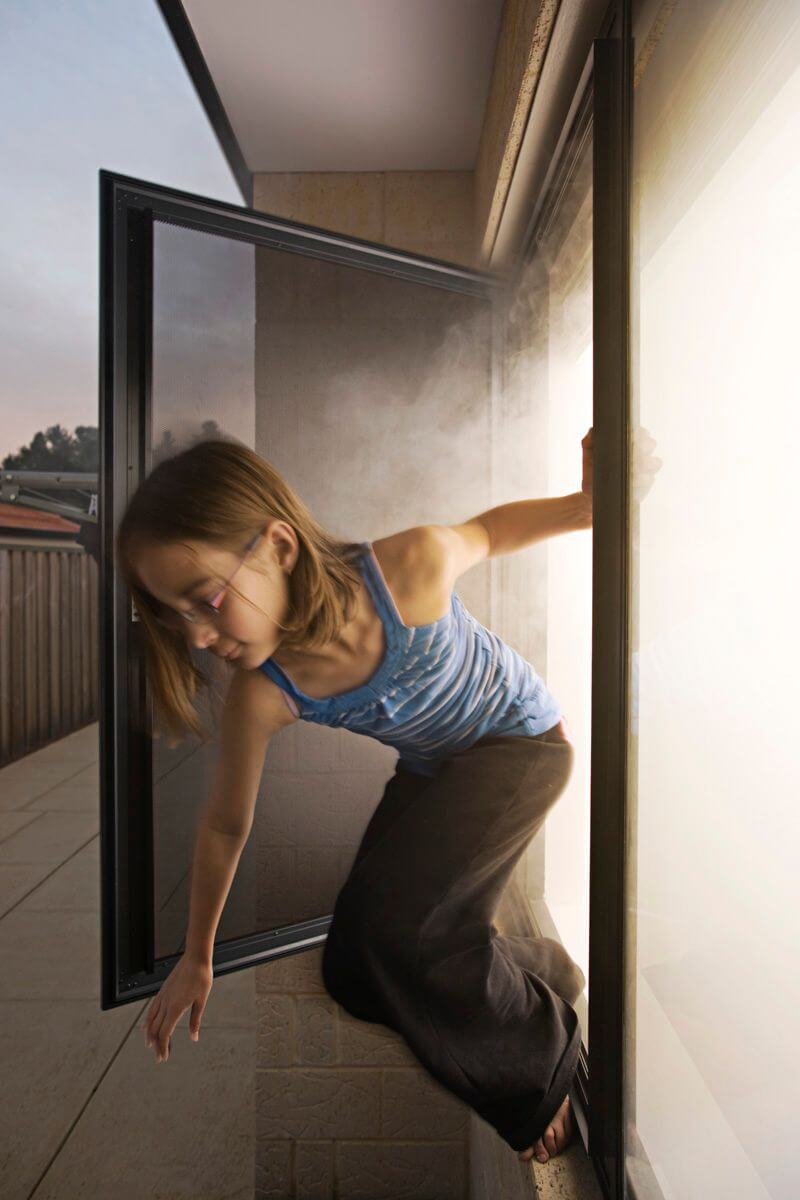 A Girl Coming Out From The Emergency Exit Door — Clearshield Security Screens in Bomaderry, NSW