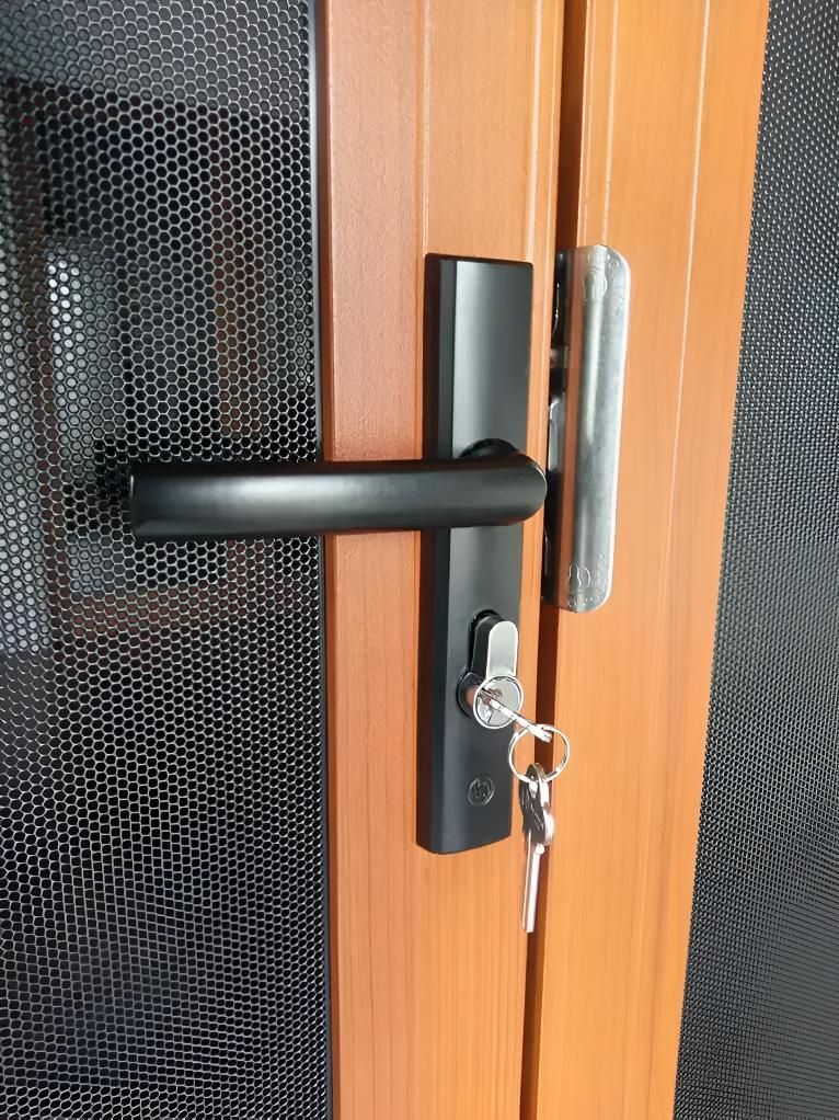 A Close Up of a Door With a Black Handle and Keys — Clearshield Security Screens in Wollongong, NSW