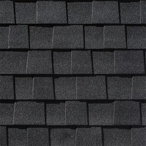 Close-up of dark gray asphalt roof shingles in a staggered pattern