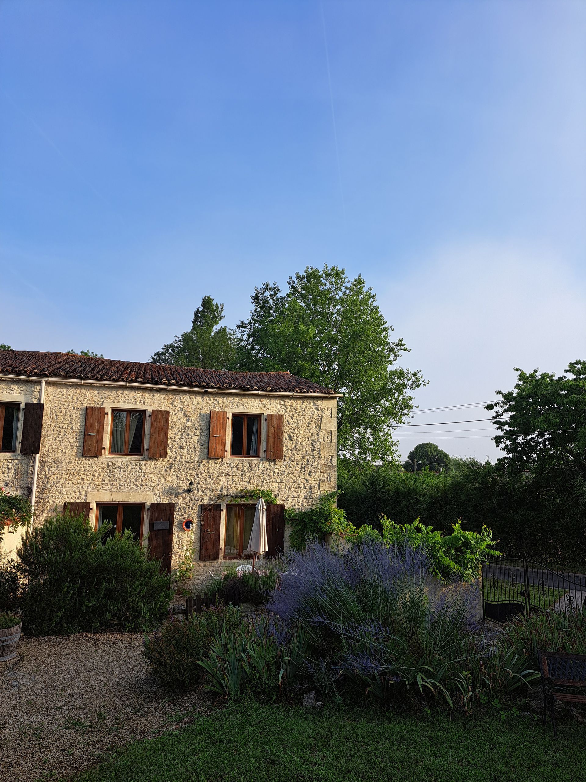 stenen huisje in Frankrijk met pannendak en houten luiken bruin gekleurd, lavendel op de voorgrond