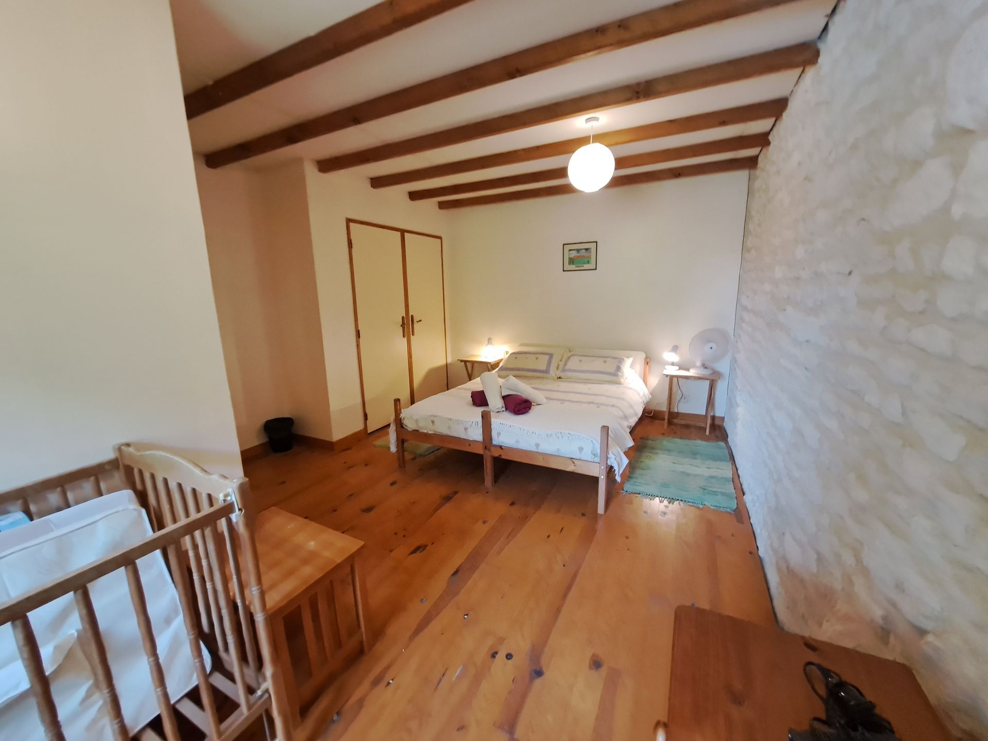 double bedroom with wooden floorboards and ceiling beams