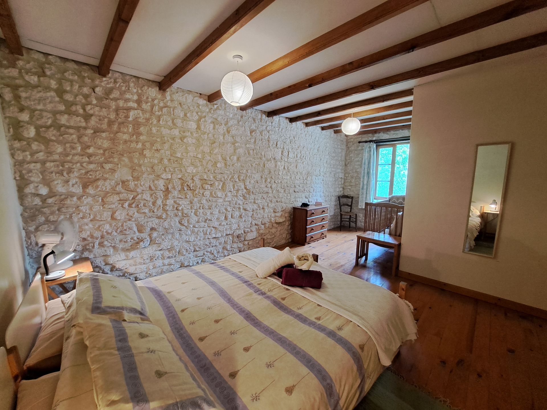 tweepersoonsslaapkamer met houten vloer en balkenplafond