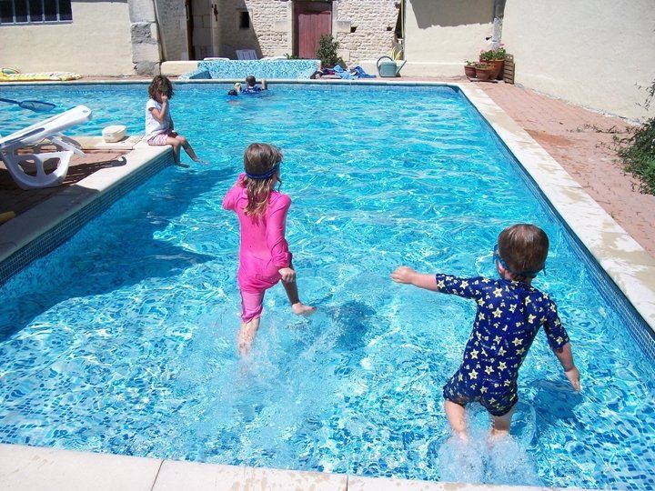 two young children running into a shallow pool