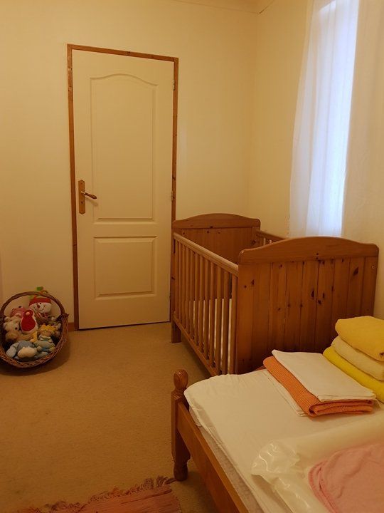A babies bedroom with wooden cot