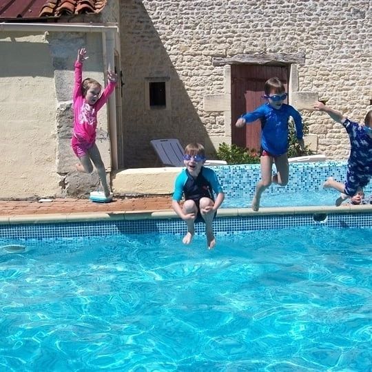 4 kinderen springen in een zwembad