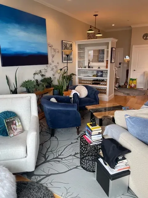 A living room filled with furniture and a painting on the wall