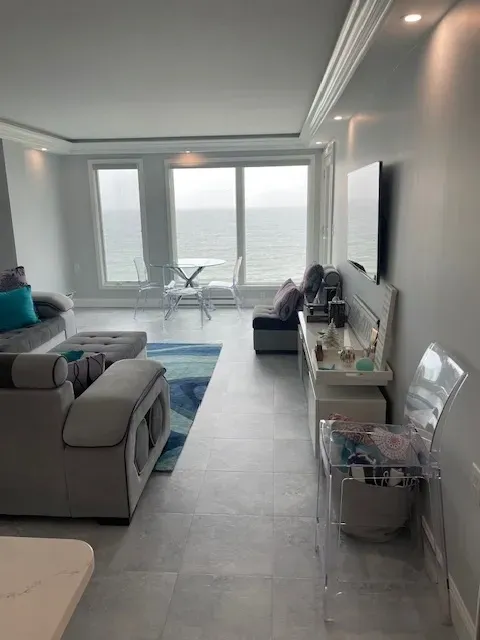 A living room with a couch , chair , table and television.