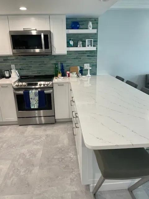 A kitchen with stainless steel appliances and white cabinets