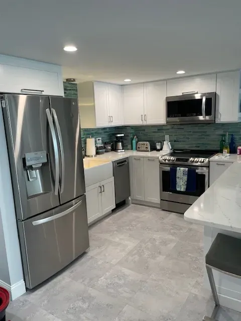 A kitchen with stainless steel appliances and white cabinets