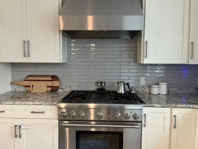 A kitchen with stainless steel appliances and white cabinets