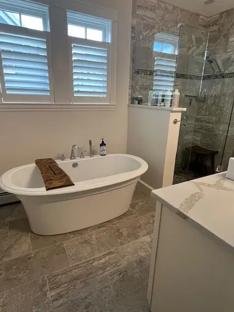 A bathroom with a bathtub and a walk in shower.