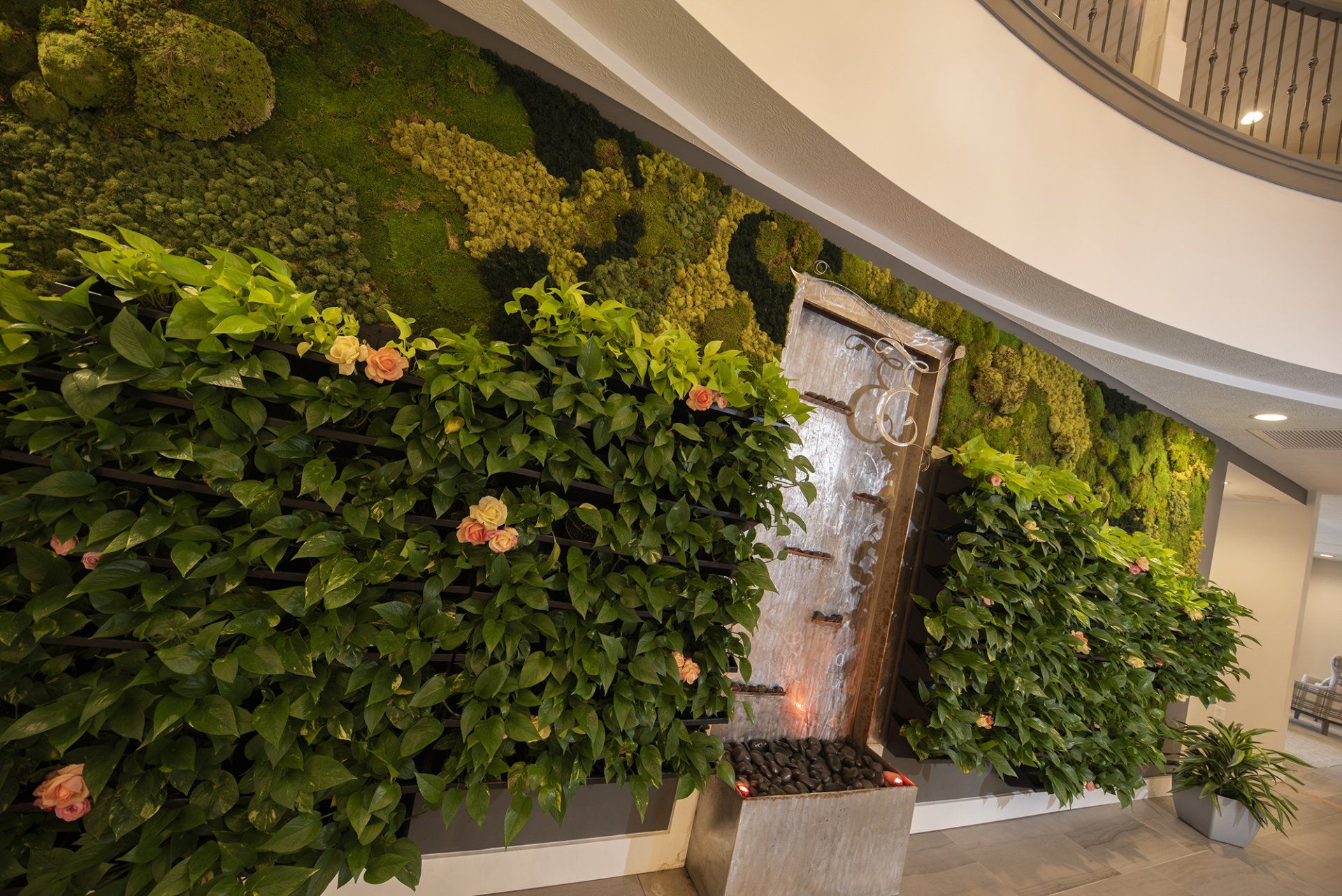 Green wall with waterfall feature, indoor office space.