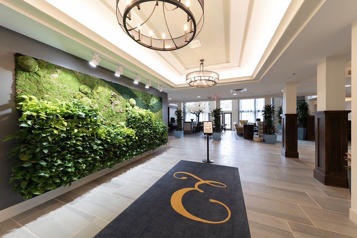 Lobby with living wall, gray and white decor, dark blue rug with gold