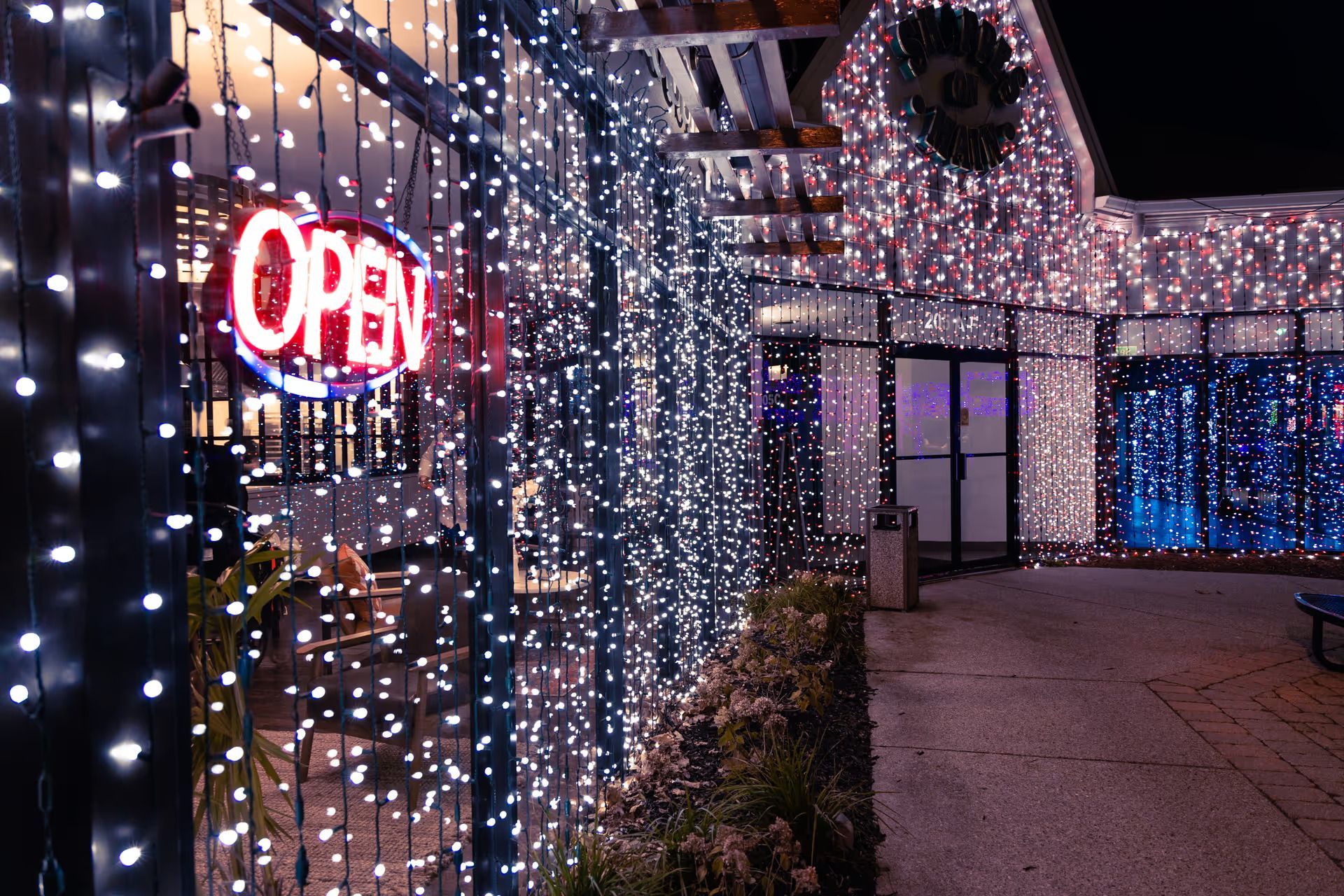 A store front with a neon sign that says open