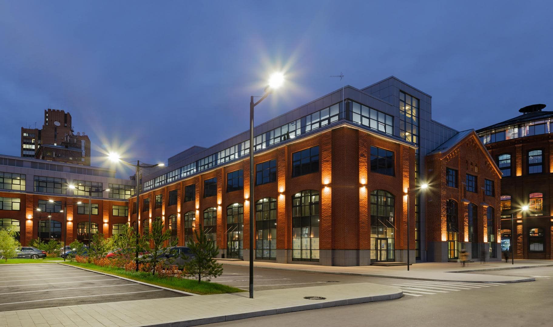 A large brick building with a lot of windows is lit up at night.