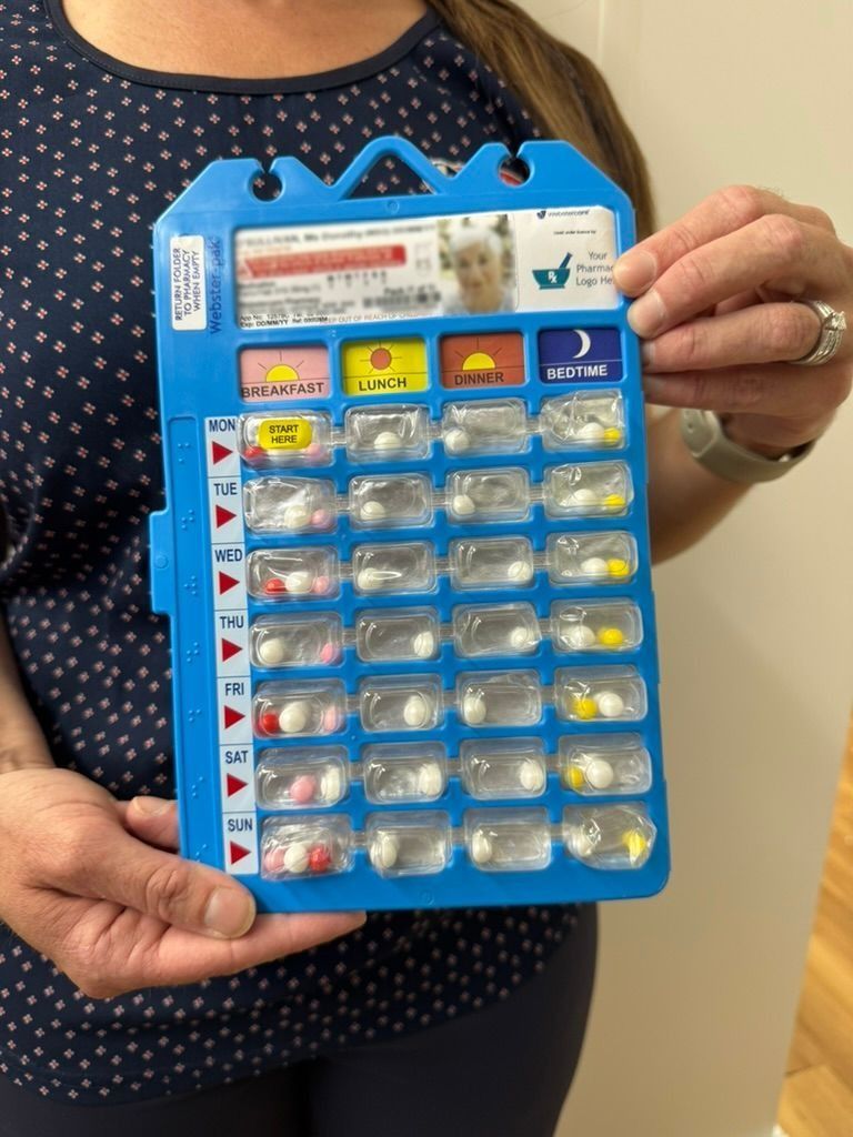 a Weekly Pill Box With Pills and a Glass of Water on a Table — Warners Bay Pharmacy In Warners Bay, NSW