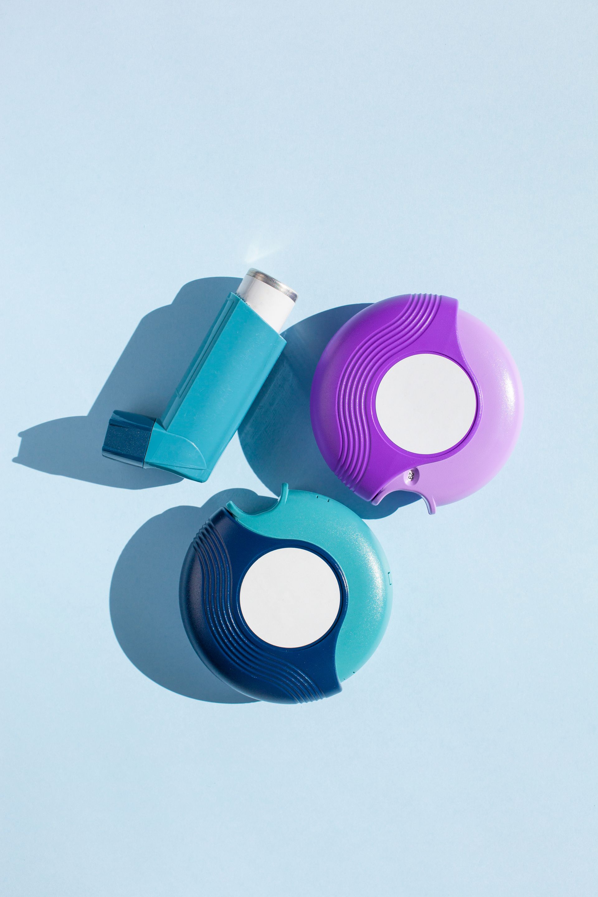 a Woman is Sitting on a Bed Holding an Inhaler — Warners Bay Pharmacy In Warners Bay, NSW
