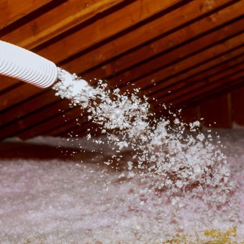 A white hose is spraying white foam into a room