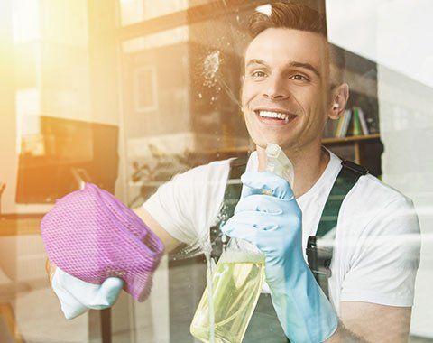 Window Washing — Worker Cleaning a Glass Window in Gibsonia, PA
