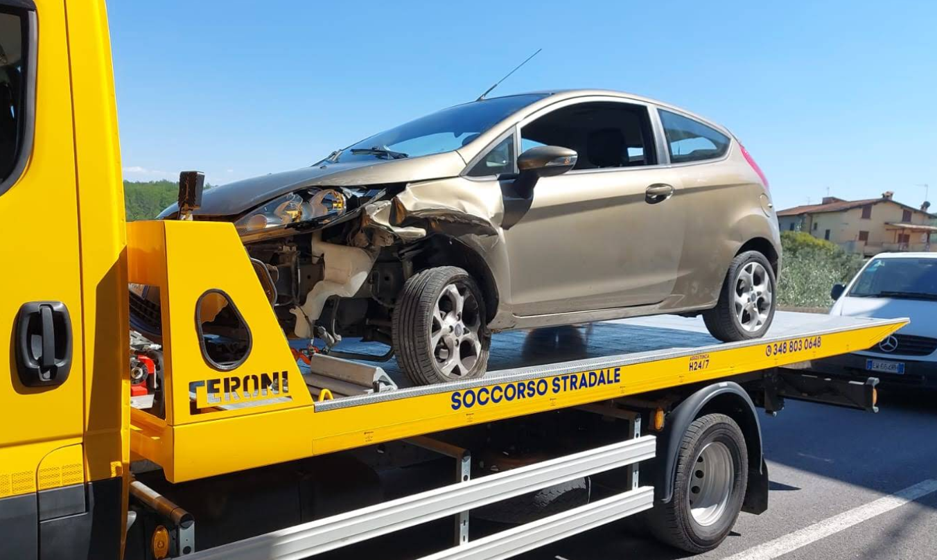 Auto color oro danneggiata su un carro attrezzi; parte anteriore gravemente distrutta. 