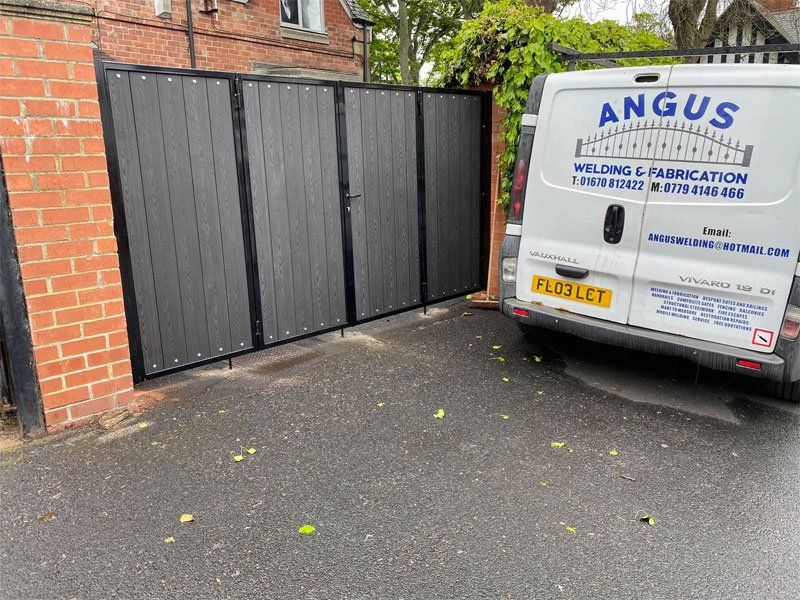 Bifolding gates fitted with charcoal black composite boards and letterbox
