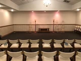 A room with rows of chairs and candles in it.