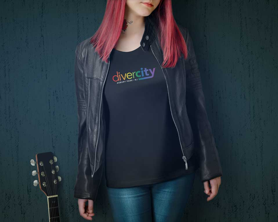 A woman wearing a black shirt that says diversity is standing next to a guitar in divercity clothing