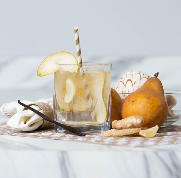 A glass of pear juice with a straw in it