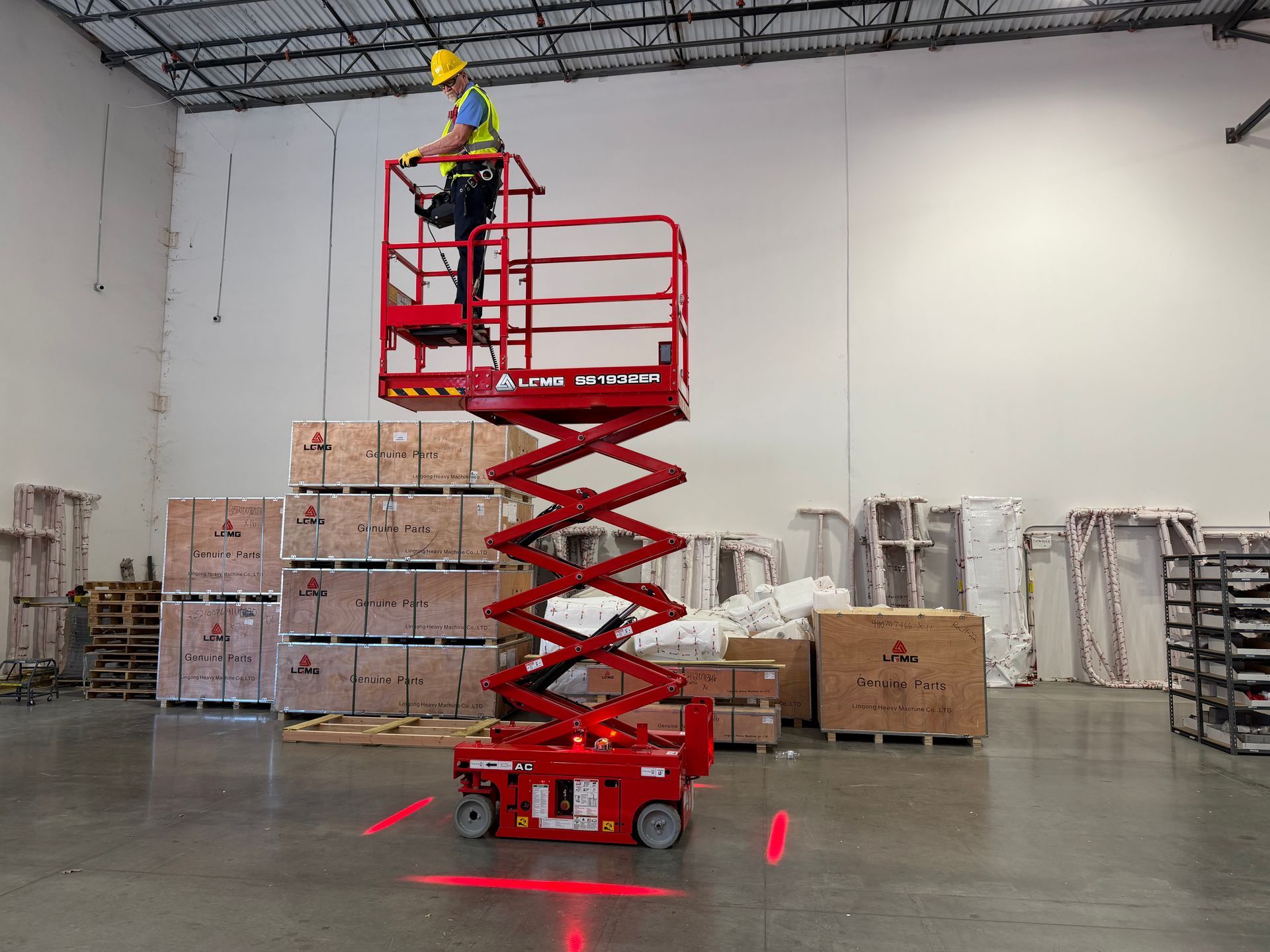 Construction equipment display booth with red machinery, LCMG sign, and people.